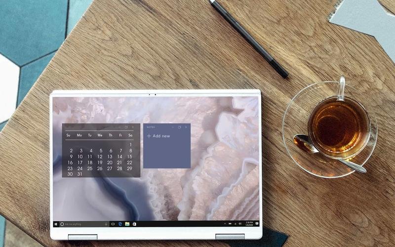 Laptop and planner beside a cup of tea