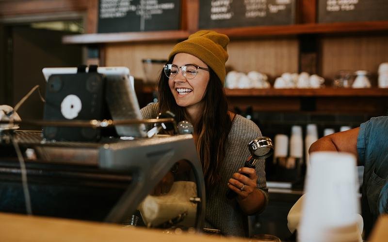 Small café owner smiling at the counter